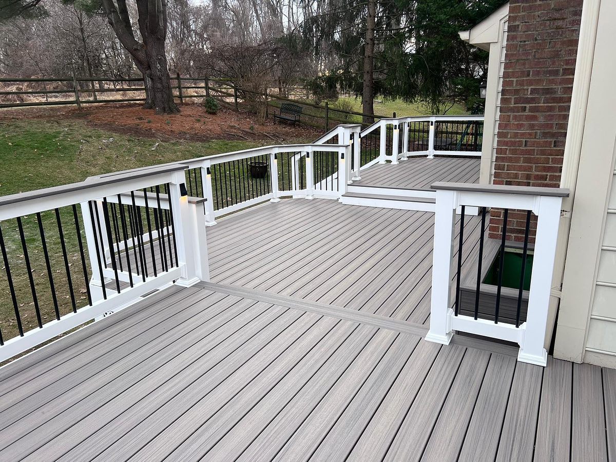 Rebuilt gray composite deck with white railing and black balusters in Vienna, Virginia